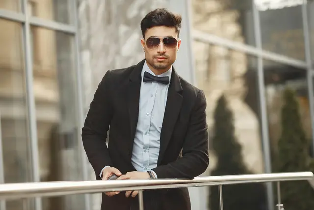 Man in suit with bow tie and aviator sunglasses